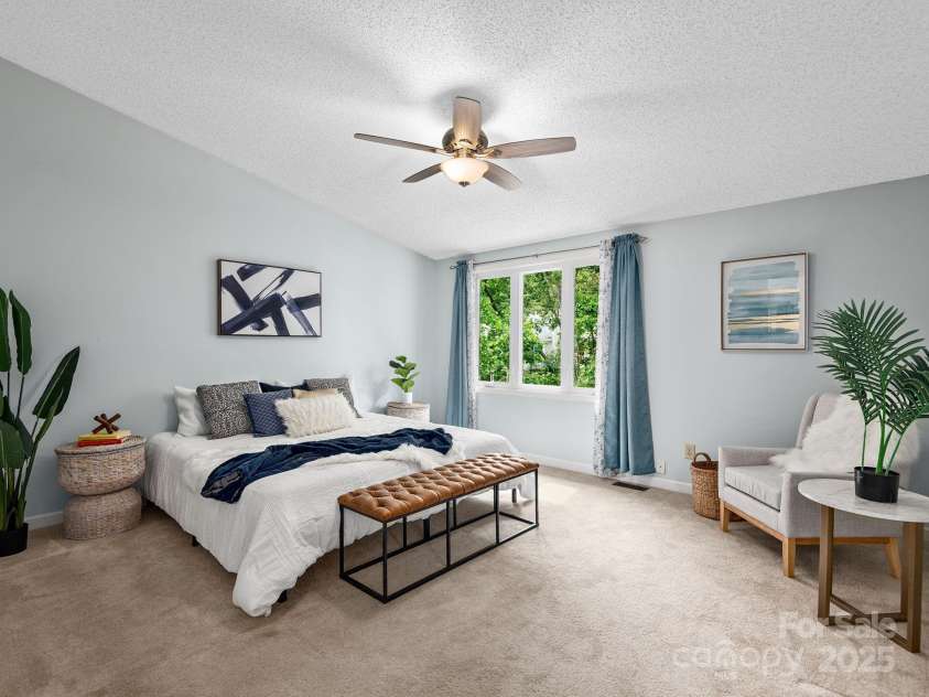 42 Hollybrook Drive, Asheville, NC 28803.  MLS# CAR4256176, YatesRealty ID 27329. Light filled primary bedroom features tall sloped ceilings and windows framing surrounding forest