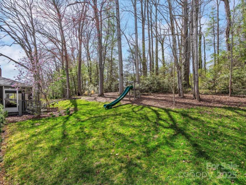 324 Woody Lane, Asheville, NC 28804.  MLS# CAR4235932, YatesRealty ID 27341. Large yard includes posts in concrete for a hammock and your kids or grandkids will love the slide