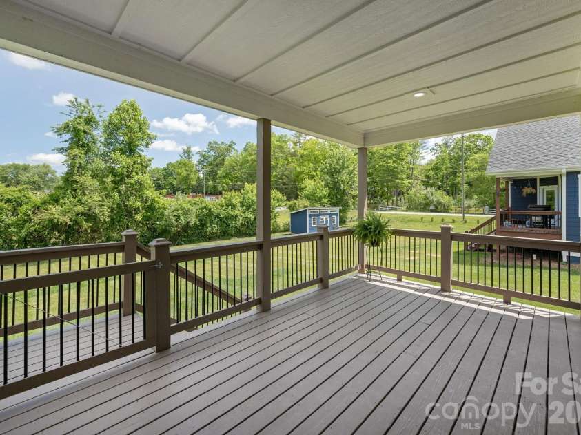 36 Windy Acres Knoll Drive, Hendersonville, NC 28792.  MLS# CAR4377336, YatesRealty ID 27383. Covered Porch & Backyard – Expanded covered deck overlooks the large, level backyard, creating an ideal outdoor living space.