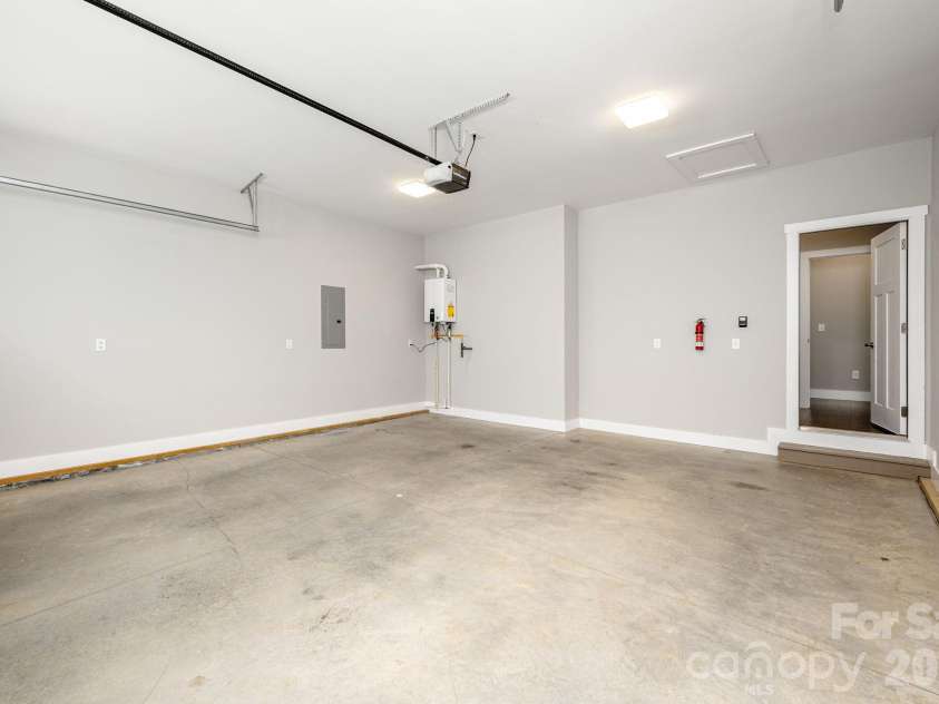 36 Windy Acres Knoll Drive, Hendersonville, NC 28792.  MLS# CAR4377336, YatesRealty ID 27383. Garage Interior – Spacious two-car garage offers ample room for parking, storage, and workshop space, with direct access to the home.