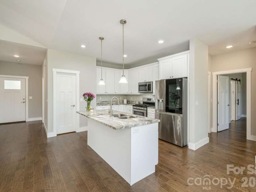 36 Windy Acres Knoll Drive, Hendersonville, NC 28792.  MLS# CAR4377336, YatesRealty ID 27383. Kitchen & Entry – The open layout seamlessly connects the kitchen to the main living areas, creating an ideal space for everyday living and entertaining.Walk-In Pantry – Large walk-in pantry with wire shelv