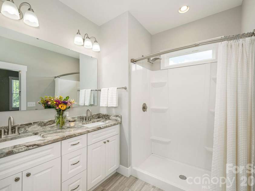 36 Windy Acres Knoll Drive, Hendersonville, NC 28792.  MLS# CAR4377336, YatesRealty ID 27383. Primary Bathroom – The primary bath features a dual-sink granite vanity, oversized walk-in shower, and contemporary finishes designed for comfort and convenience.