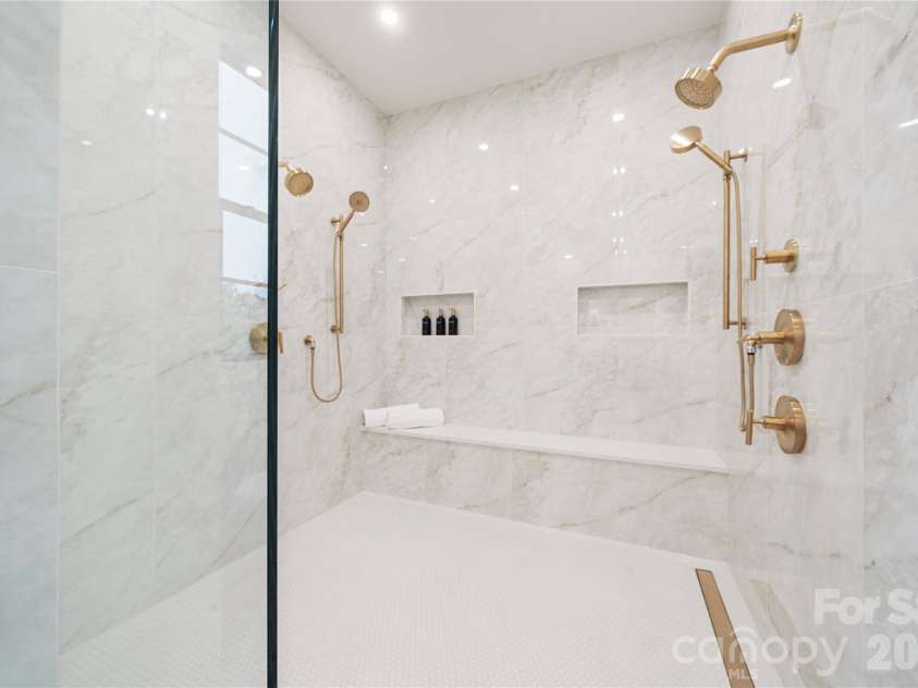 409 Queens Road, Charlotte, NC 28207.  MLS# CAR4425871, YatesRealty ID 274. The oversized primary shower is marble, with dual shower systems, for your daily spa experience.