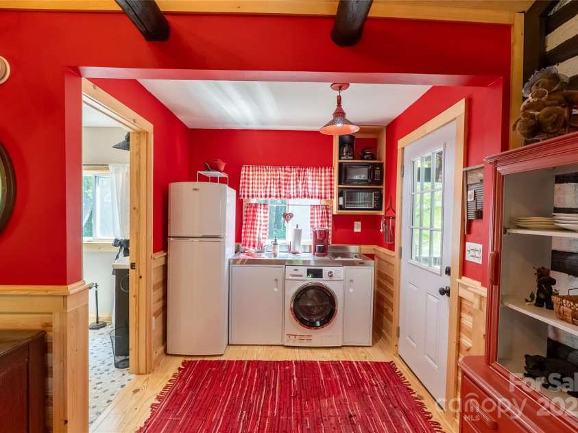 225 Wilderness Road, Tryon, NC 28782.  MLS# CAR4272632, YatesRealty ID 27434. Compact Kitchen, with washer/dryer unit.