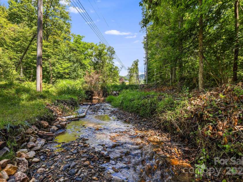 66 Volunteer Drive, Burnsville, NC 28714.  MLS# CAR4278537, YatesRealty ID 27449. Creek at bottom of property