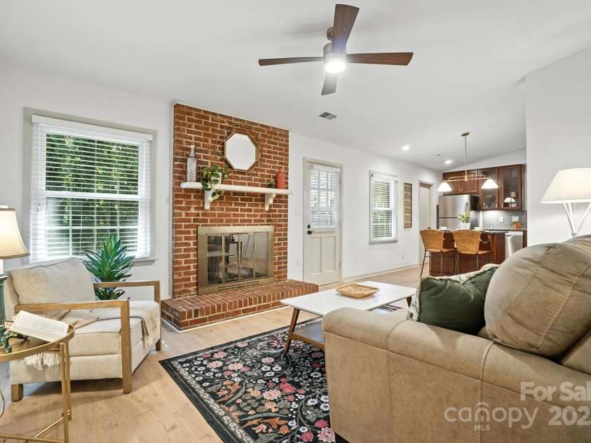 9334 New Towne Drive, Matthews, NC 28105.  MLS# CAR4275709, YatesRealty ID 27460. Living room featuring brick fireplace.