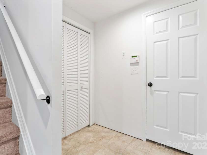 9833 White Cascade Drive, Charlotte, NC 28269.  MLS# CAR4275187, YatesRealty ID 27475. Basement stair, door to 2-car garage and storage with laundry chute