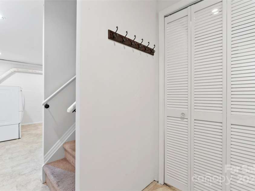 9833 White Cascade Drive, Charlotte, NC 28269.  MLS# CAR4275187, YatesRealty ID 27475. Basement stair, storage with laundry chute and laundry area