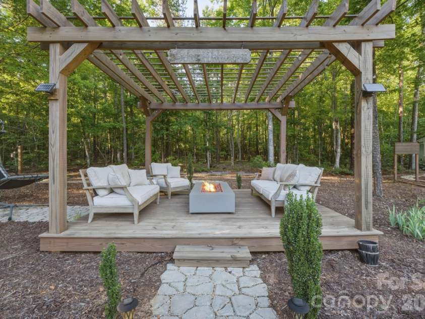 9717 Lancaster Highway, Waxhaw, NC 28173.  MLS# CAR4371188, YatesRealty ID 27507. Or under the pergola on the deck in front of the fire pit table