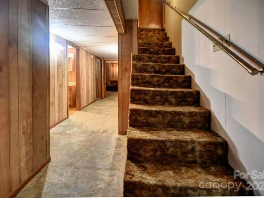 501 Locust Grove Drive, Waynesville, NC 28785.  MLS# CAR4282099, YatesRealty ID 27527. Stairs to the main level in a partially finished area of the basement