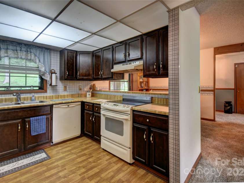 501 Locust Grove Drive, Waynesville, NC 28785.  MLS# CAR4282099, YatesRealty ID 27527. The kitchen has a pass-through to the dining area