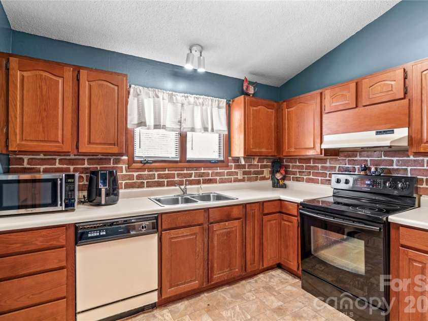 1404 Wellington Hills Circle, Salisbury, NC 28147.  MLS# CAR4383791, YatesRealty ID 27540. Kitchen has custom brick backsplash, microwave and airfryer.