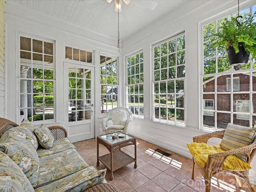 702 Hayne Street, Monroe, NC 28112.  MLS# CAR4376608, YatesRealty ID 27571. Bright sunroom filled with natural light and panoramic garden views.