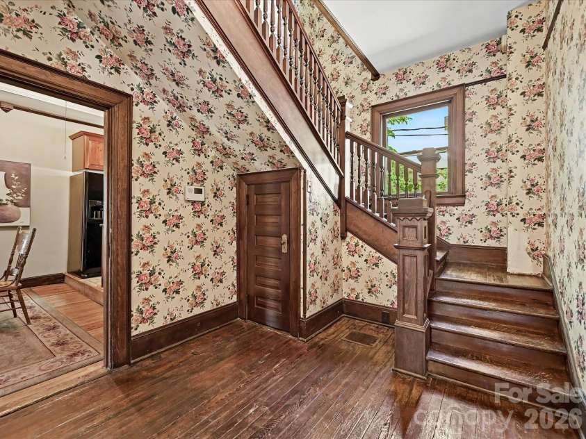 702 Hayne Street, Monroe, NC 28112.  MLS# CAR4376608, YatesRealty ID 27571. Historic staircase and original woodwork create a striking architectural focal point.