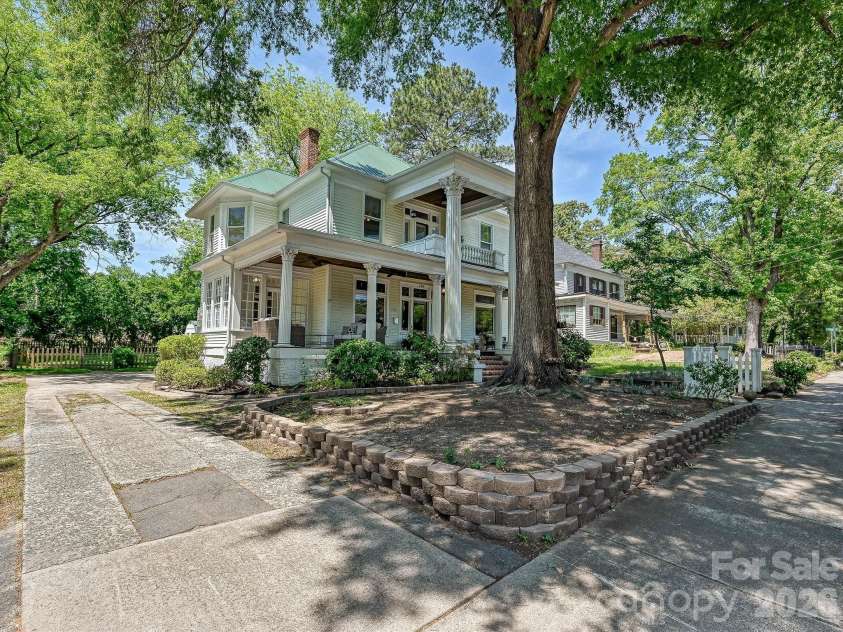 702 Hayne Street, Monroe, NC 28112.  MLS# CAR4376608, YatesRealty ID 27571. Iconic wraparound porch and grand columns create unforgettable curb appeal.