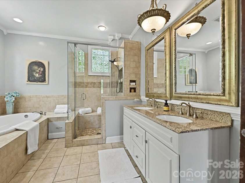 702 Hayne Street, Monroe, NC 28112.  MLS# CAR4376608, YatesRealty ID 27571. Luxurious bath with dual vanities, soaking tub, and beautifully updated finishes.