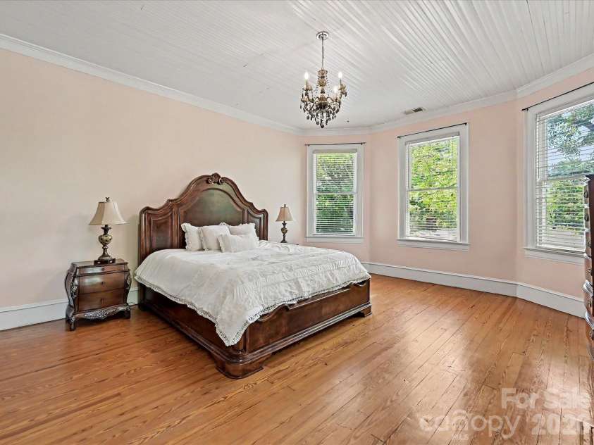 702 Hayne Street, Monroe, NC 28112.  MLS# CAR4376608, YatesRealty ID 27571. Spacious primary bedroom filled with natural light and classic historic elegance.