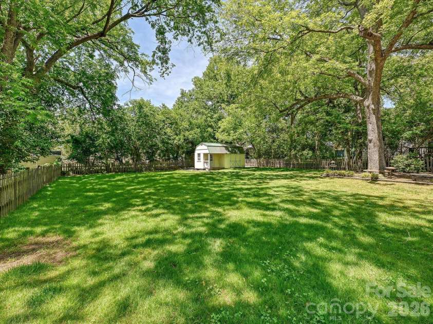 702 Hayne Street, Monroe, NC 28112.  MLS# CAR4376608, YatesRealty ID 27571. Sprawling backyard with lush green space and timeless estate-like setting.