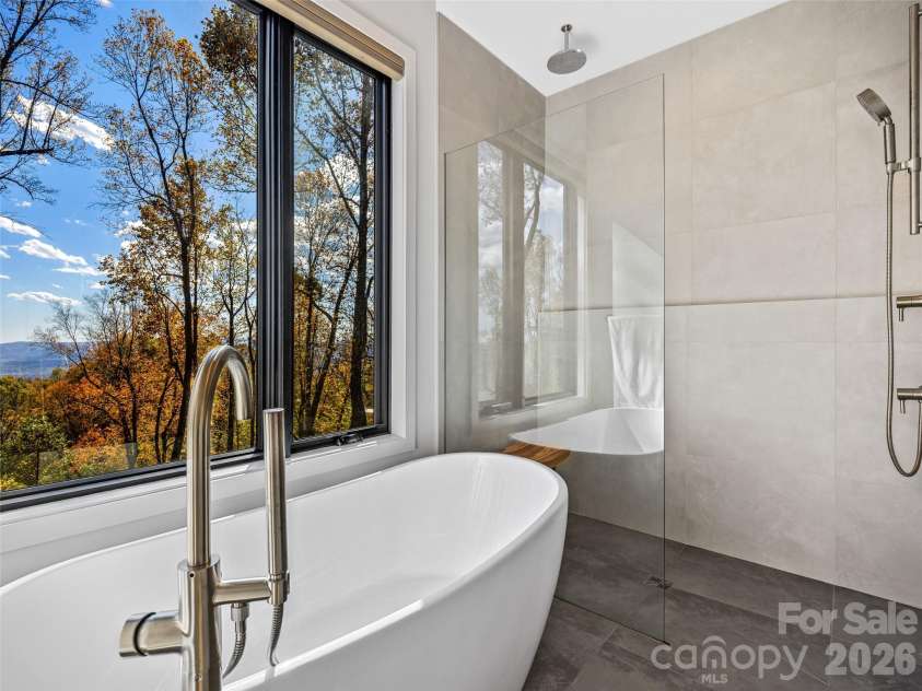 15 Laurel Ledge Way, Fletcher, NC 28732.  MLS# CAR4316029, YatesRealty ID 2758. Soaking tub and shower in the primary bath suite. Bath in those views!