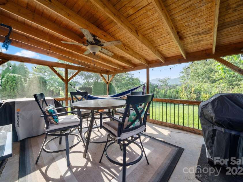 34 Dove Hollow Road, Fletcher, NC 28732.  MLS# CAR4279098, YatesRealty ID 27596. Covered screened-in porch in the rear of the home overlooks the peaceful mountain views.