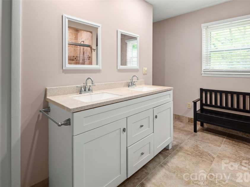 83 Honeysuckle Lane, Burnsville, NC 28714.  MLS# CAR4377930, YatesRealty ID 27630. Updated primary bathroom includes dual sinks, walk in shower and walk in closets