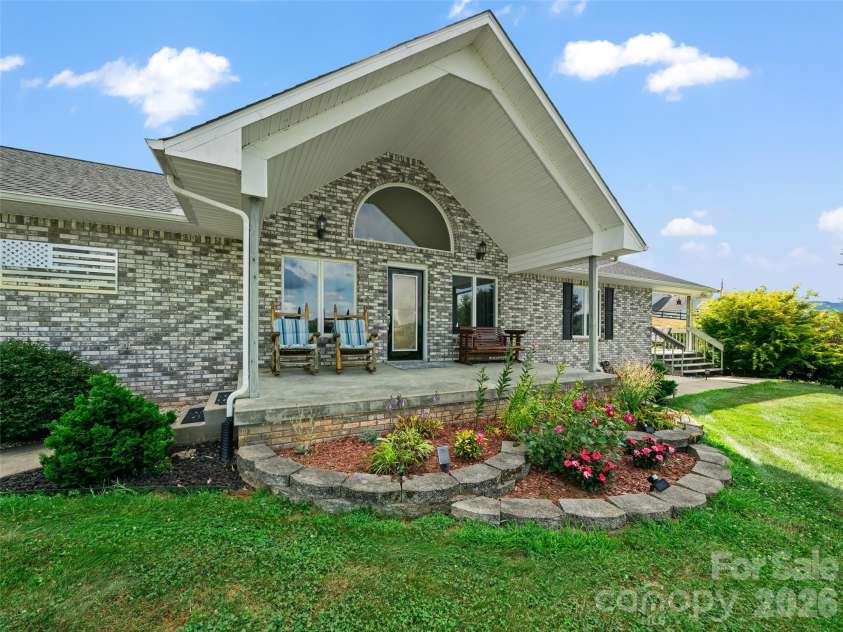 124 Dogwood Circle, Burnsville, NC 28714.  MLS# CAR4290145, YatesRealty ID 2764. Front Porch with carefully cultivated Landscaping and a man-made pond.