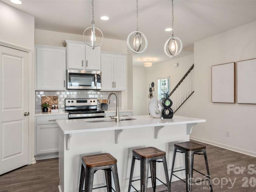 13205 Gadwal Pintail Drive, Charlotte, NC 28262.  MLS# CAR4380012, YatesRealty ID 27656. The island features bar seating and modern light fixtures.