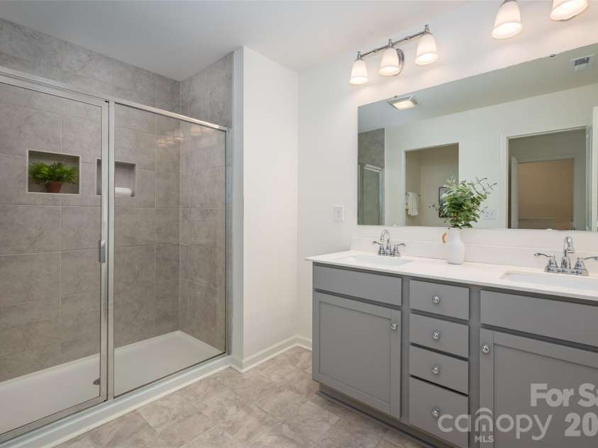 13205 Gadwal Pintail Drive, Charlotte, NC 28262.  MLS# CAR4380012, YatesRealty ID 27656. The primary bathroom features an oversized walk-in shower and a double vanity with updated fixtures.