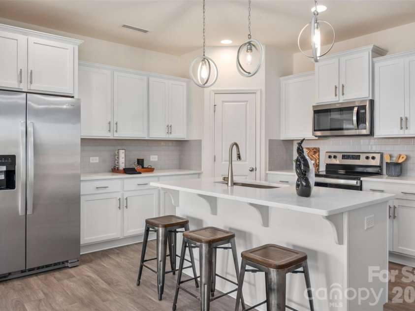 13205 Gadwal Pintail Drive, Charlotte, NC 28262.  MLS# CAR4380012, YatesRealty ID 27656. This gorgeous white kitchen is sure to delight the chef in the house!  The refrigerator with icemaker conveys with the home.