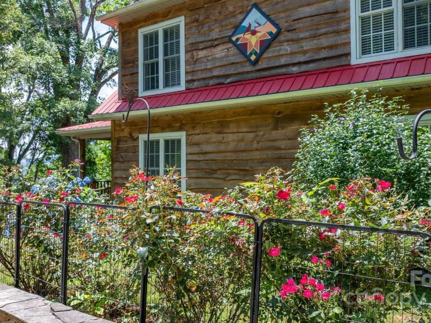 715 Sunset Mountain Road, Bakersville, NC 28705.  MLS# CAR4276207, YatesRealty ID 27672. Flowers along the rock wall of driveway.