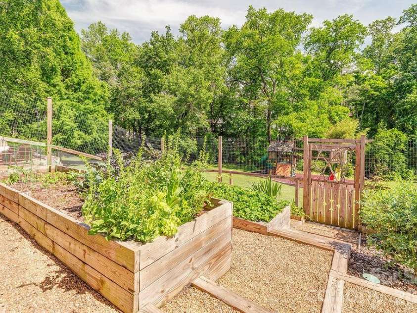201 Skytop Farm Lane, Hendersonville, NC 28791.  MLS# CAR4387664, YatesRealty ID 27689. Raised bed gardens with established berries and perennials and room for your favorite veg. 