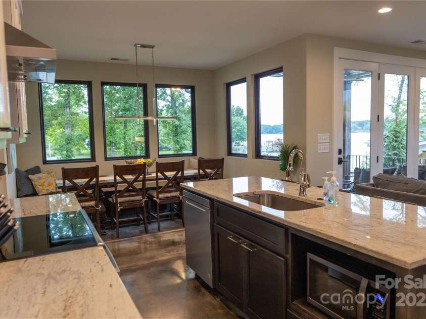 113 Angler Place, Mooresville, NC 28117.  MLS# CAR4217106, YatesRealty ID 2772. Open space with kitchen, dining table and living overlooking Lake.