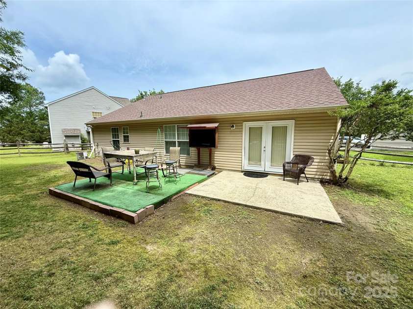 7267 Sandown Court, Harrisburg, NC 28075.  MLS# CAR4268335, YatesRealty ID 27737. Back patio. Perfect for entertaining! The sellers built a custom enclosure for an outdoor TV, which conveys with the property!