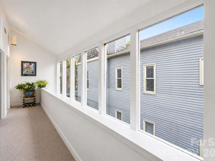 515 Poplar Street, Charlotte, NC 28202.  MLS# CAR4378649, YatesRealty ID 27783. Light-filled upper hallway lined with oversized windows, creating a bright and airy transition space throughout the home