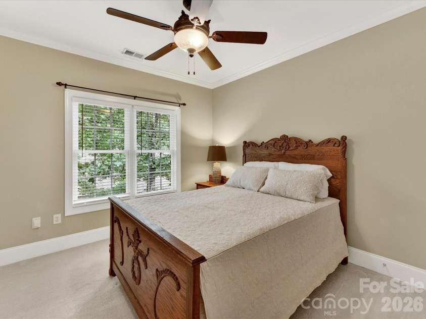 11615 Hidden Forest Lane, Davidson, NC 28036.  MLS# CAR4386264, YatesRealty ID 27816. Bright and spacious secondary bedroom features large windows, neutral tones, and a comfortable layout perfect for family or guests.