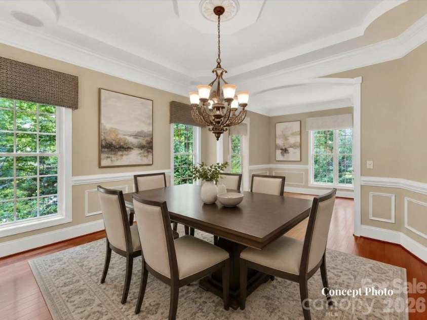 11615 Hidden Forest Lane, Davidson, NC 28036.  MLS# CAR4386264, YatesRealty ID 27816. Concept photo of virtually staged elegant formal dining room features extensive crown molding, tray ceiling details, hardwood floors, and seamless flow into the adjoining living spaces for effortless entertaining.