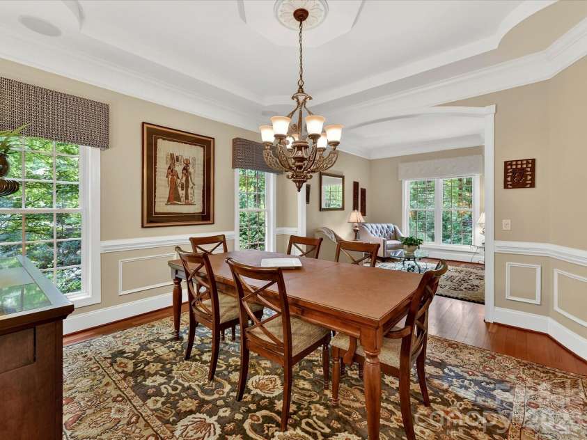 11615 Hidden Forest Lane, Davidson, NC 28036.  MLS# CAR4386264, YatesRealty ID 27816. Elegant formal dining room features extensive crown molding, tray ceiling details, hardwood floors, and seamless flow into the adjoining living spaces for effortless entertaining.