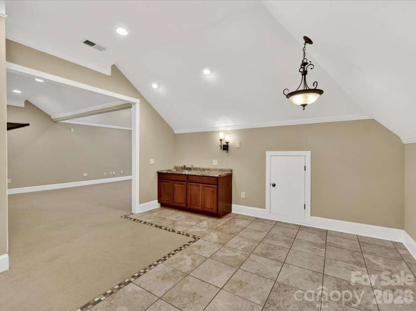 11615 Hidden Forest Lane, Davidson, NC 28036.  MLS# CAR4386264, YatesRealty ID 27816. Expansive third-level bonus room offers incredible flexibility with vaulted ceilings, recessed lighting, built-in wet bar, and abundant space for entertaining, recreation, or a home theater.