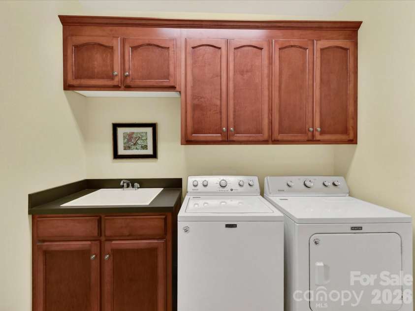 11615 Hidden Forest Lane, Davidson, NC 28036.  MLS# CAR4386264, YatesRealty ID 27816. Functional laundry room features built-in cabinetry, utility sink, and ample storage to keep everyday tasks organized and efficient.