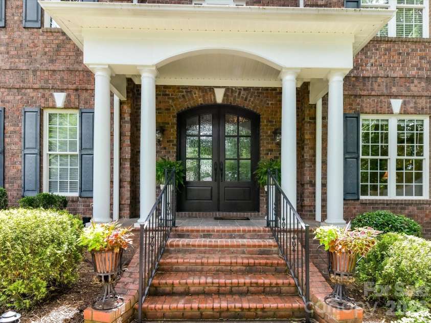 11615 Hidden Forest Lane, Davidson, NC 28036.  MLS# CAR4386264, YatesRealty ID 27816. Grand covered front porch with stately columns and elegant double entry doors creates a warm and impressive welcome home.