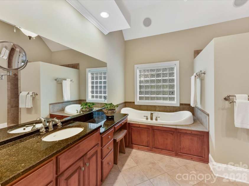 11615 Hidden Forest Lane, Davidson, NC 28036.  MLS# CAR4386264, YatesRealty ID 27816. Spa-inspired primary bath features dual vanities, granite countertops, a dedicated makeup area, and an oversized tiled walk-in shower.