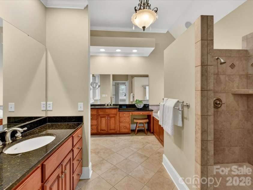 11615 Hidden Forest Lane, Davidson, NC 28036.  MLS# CAR4386264, YatesRealty ID 27816. Spa-inspired primary bath features dual vanities, granite countertops, a dedicated makeup area, and an oversized tiled walk-in shower.