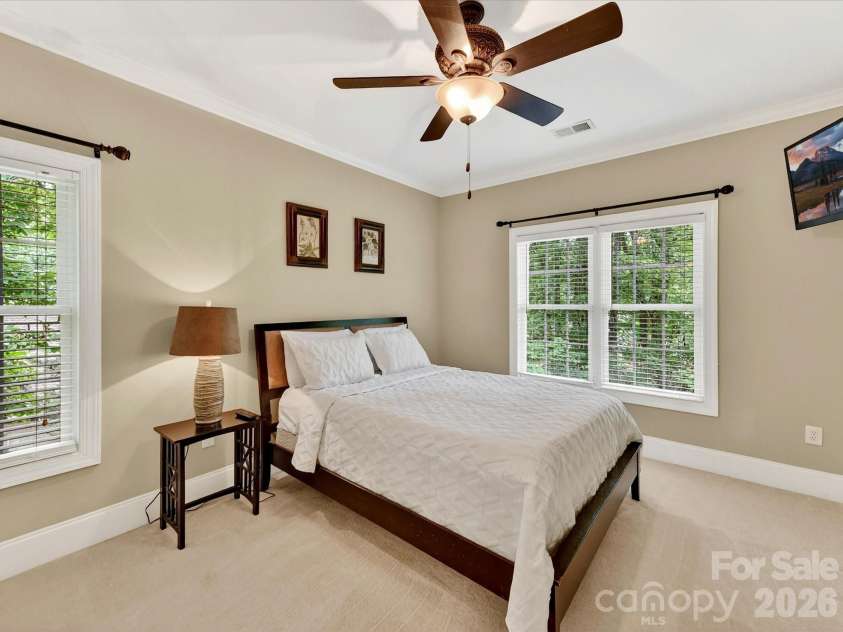 11615 Hidden Forest Lane, Davidson, NC 28036.  MLS# CAR4386264, YatesRealty ID 27816. Spacious secondary bedroom features large windows, soft natural light, and a private en-suite bath for added comfort and convenience.