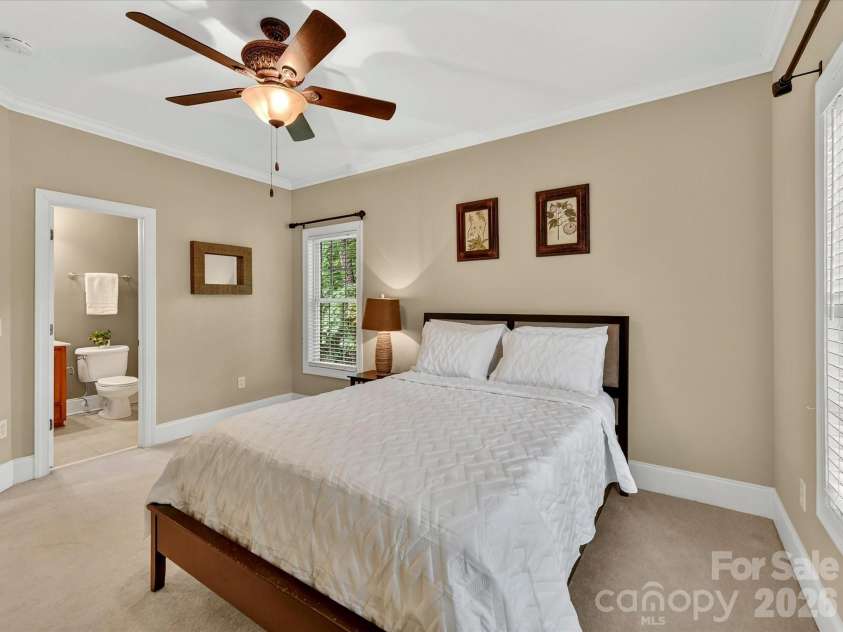 11615 Hidden Forest Lane, Davidson, NC 28036.  MLS# CAR4386264, YatesRealty ID 27816. Spacious secondary bedroom features large windows, soft natural light, and a private en-suite bath for added comfort and convenience.