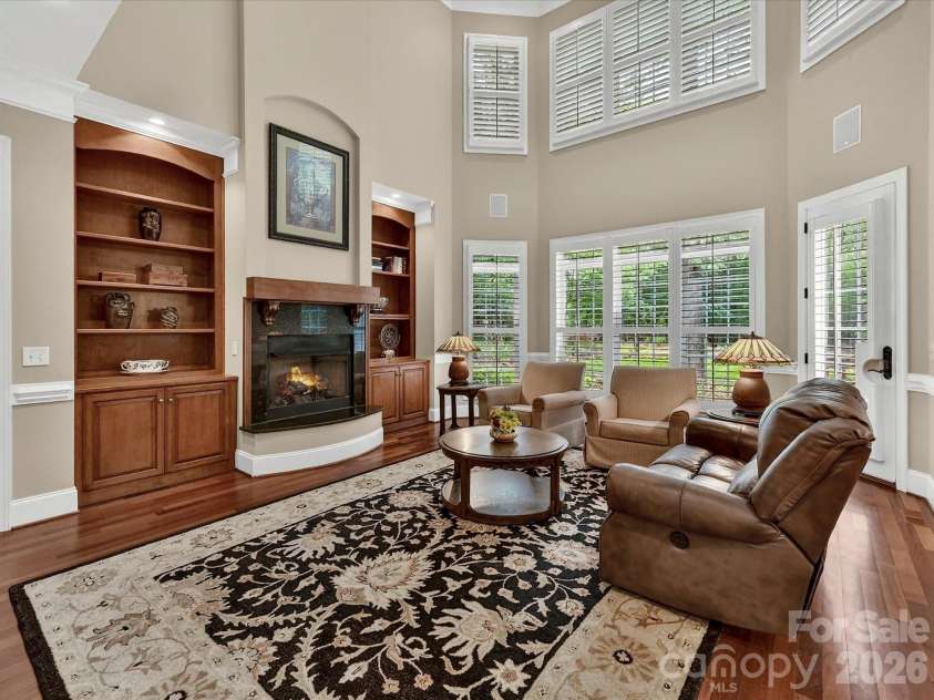 11615 Hidden Forest Lane, Davidson, NC 28036.  MLS# CAR4386264, YatesRealty ID 27816. Stunning two-story great room features soaring ceilings, custom built-ins, expansive windows, and a cozy fireplace with seamless flow into the kitchen and breakfast area.