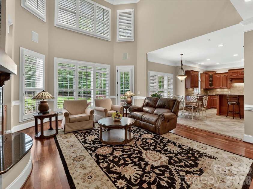 11615 Hidden Forest Lane, Davidson, NC 28036.  MLS# CAR4386264, YatesRealty ID 27816. Stunning two-story great room features soaring ceilings, custom built-ins, expansive windows, and a cozy fireplace with seamless flow into the kitchen and breakfast area.