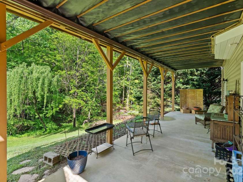 50 Pinerose Drive, Weaverville, NC 28787.  MLS# CAR4255853, YatesRealty ID 27829. Daylight Basement Patio Facing Stream and Trees