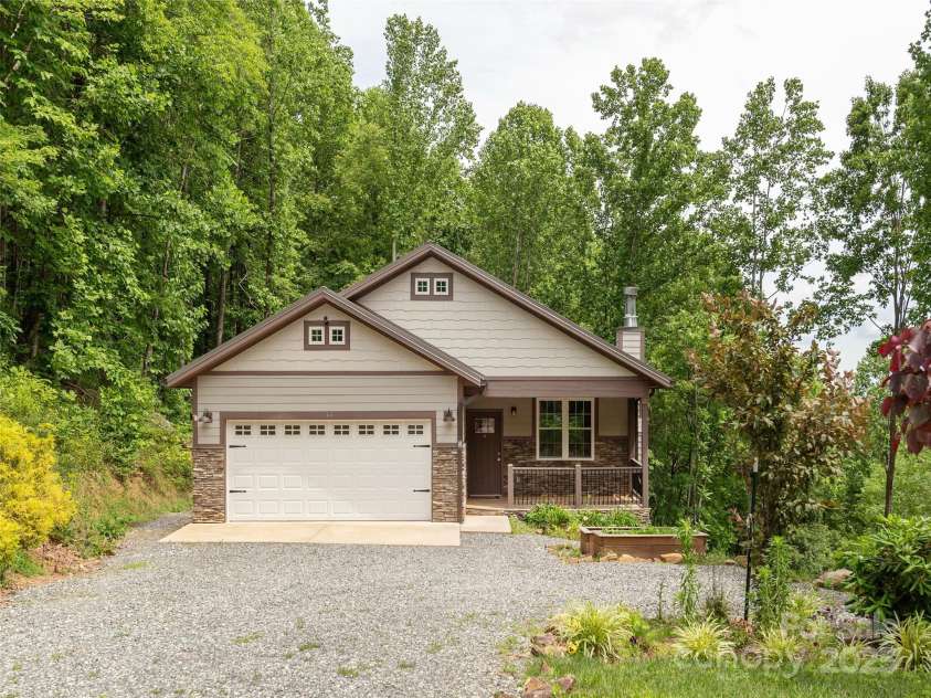 264 Splitrail Drive, Hendersonville, NC 28792.  MLS# CAR4260165, YatesRealty ID 27894. Private mountain retreat in Hendersonville! Surrounded by nature with long-range views, solar panels, and a sleek metal roof—sustainable living at its best.