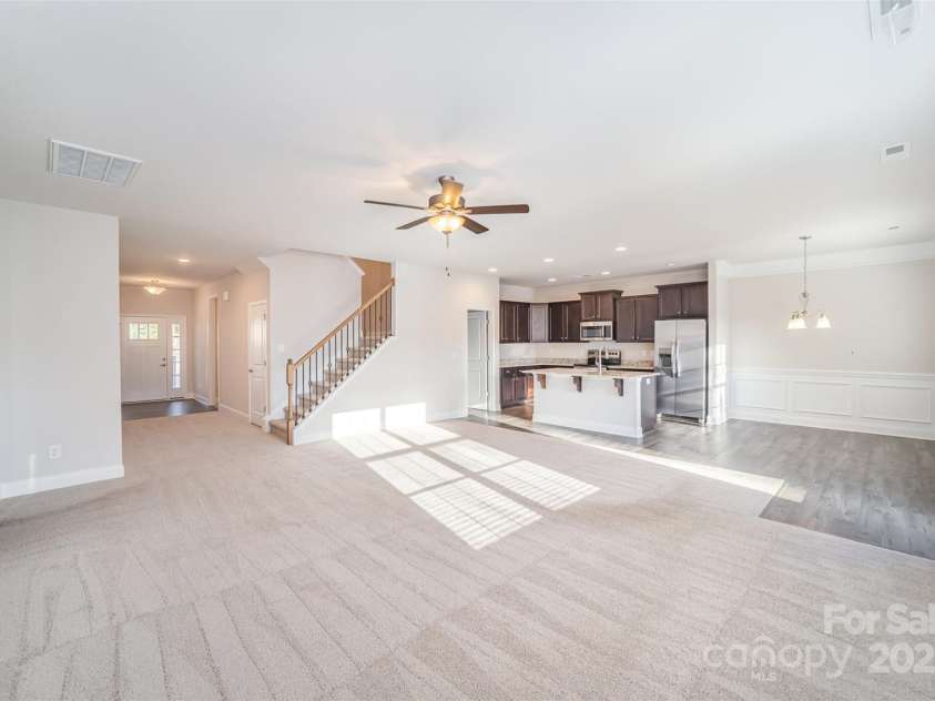 159 Rubys Way, Oakboro, NC 28129.  MLS# CAR4287834, YatesRealty ID 279. The Un-Stagged Photo_Entry Foyer, Family Room, Eat-In Dining Area featuring Crown Moulding, Chair Rail and Shadow Box features; Spacious Kitchen Area w/granite top surfaces_including an expansive island- enough seating for 3; to
