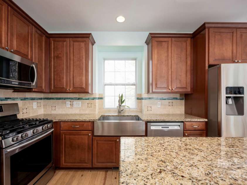 3329 Brownes Creek Road, Charlotte, NC 28269.  MLS# CAR4232626, YatesRealty ID 2790. Kitchen with gas stove and SS farmhouse sink with apron